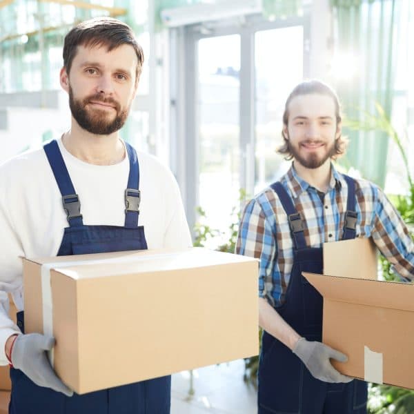 Two smiling movers carrying boxes